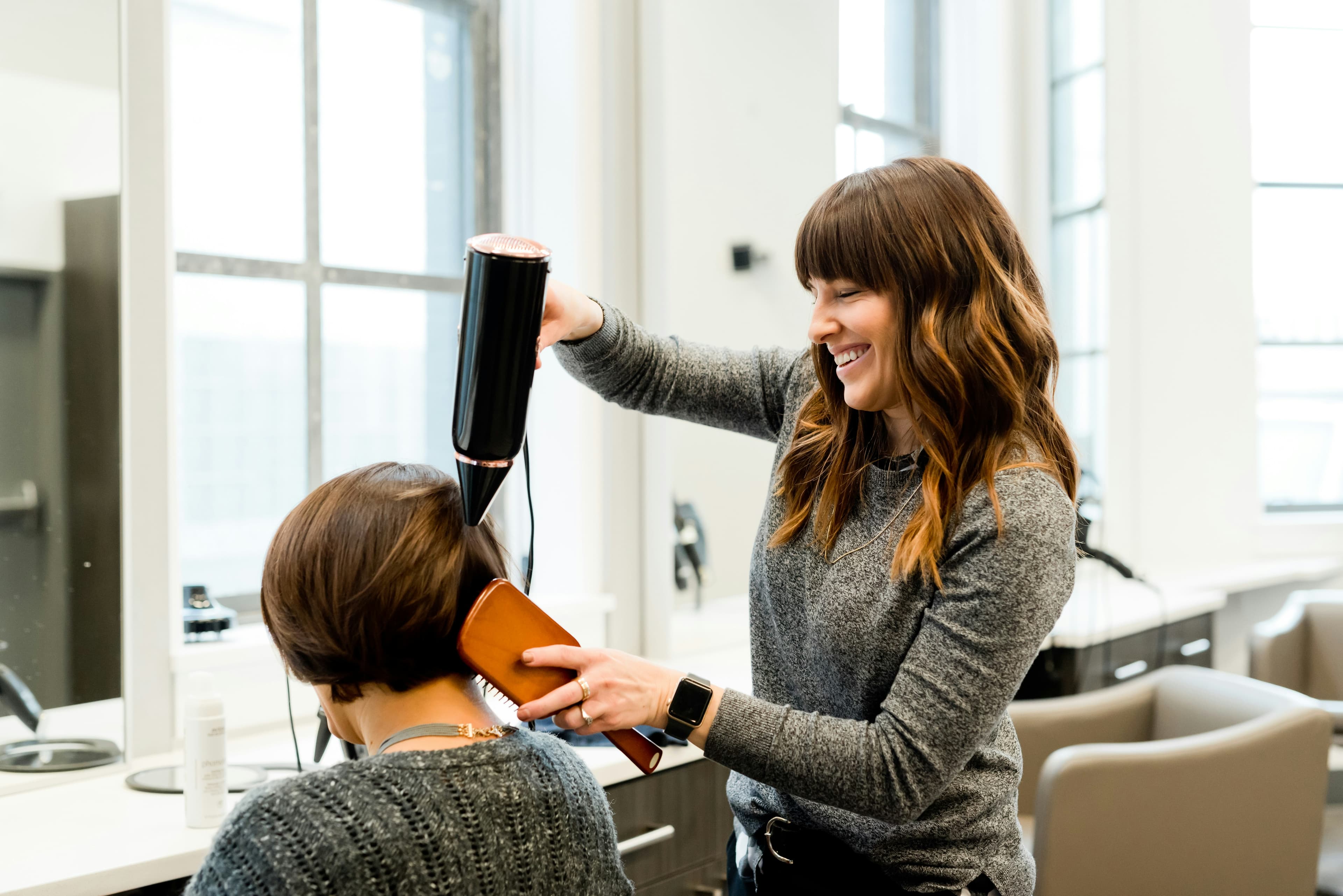 Hairdresser styling a client's hair in a salon