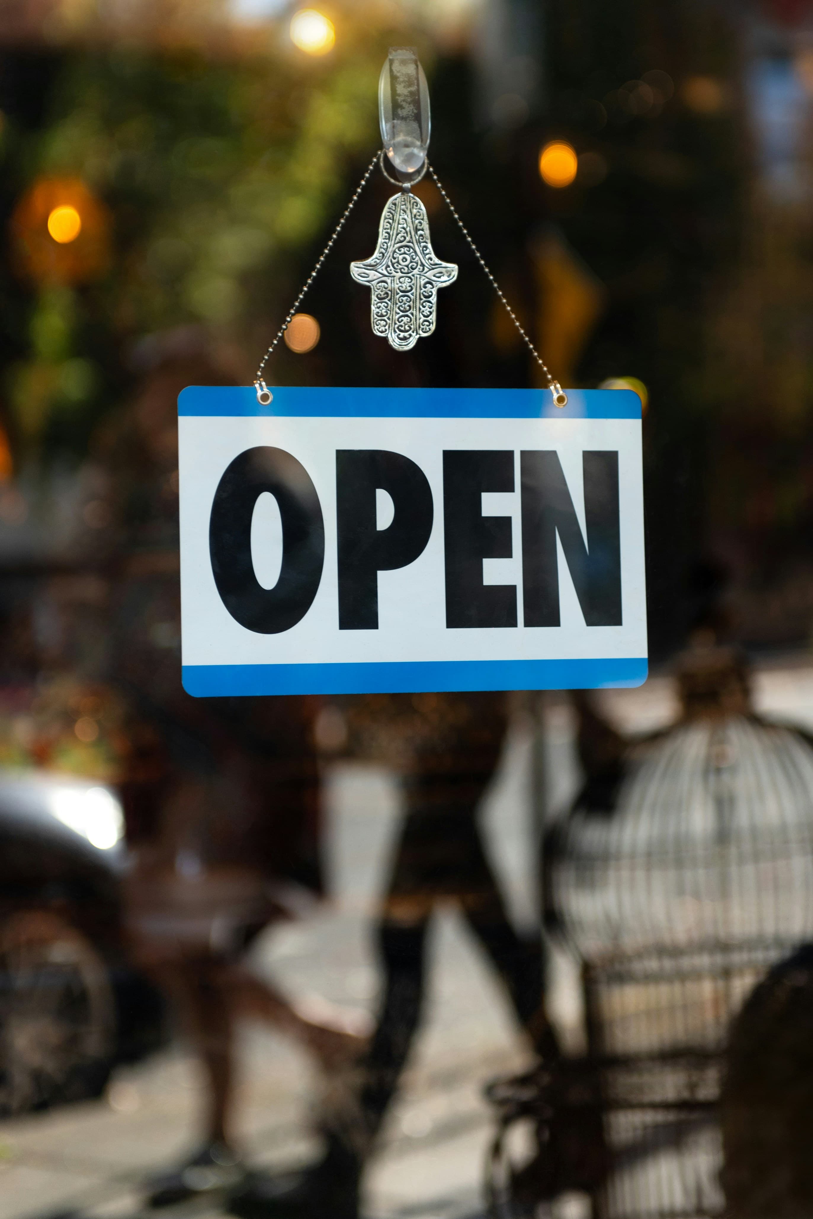 Open sign hanging in a shop window
